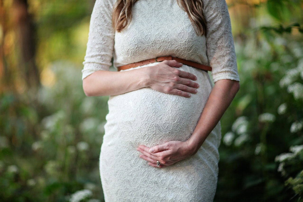 photo d'une femme enceinte en robe blanche