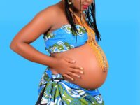 pregnant black woman in bright trendy clothes on blue background