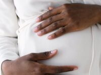 crop pregnant black woman touching belly